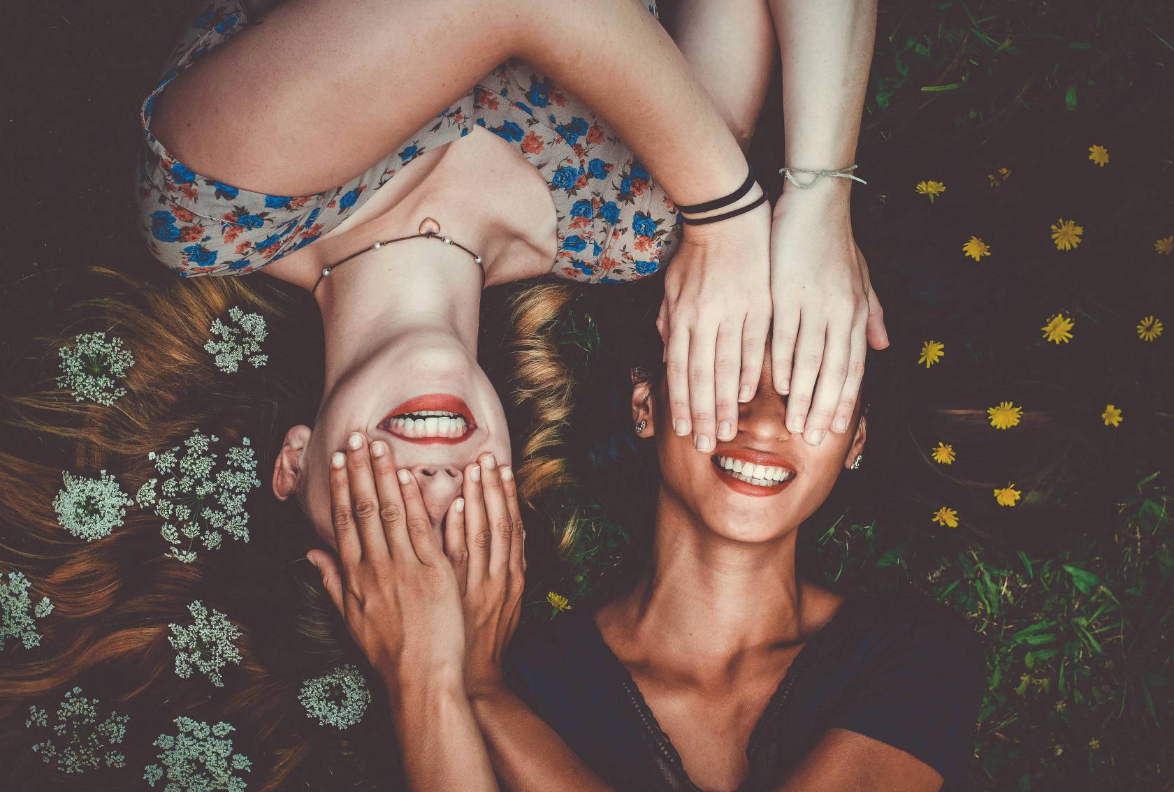 Three happy people with beautiful smiles, one wearing pink clothing.